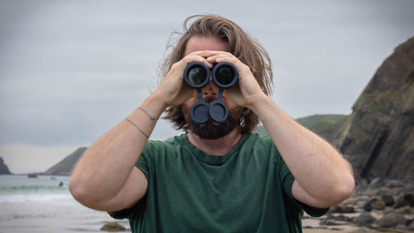 A male using the Nikon Monarch M7 8x42 binoculars, looking directly at the camera.