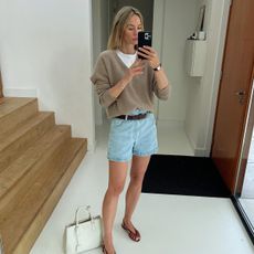 Woman wearing a sweater and denim shorts