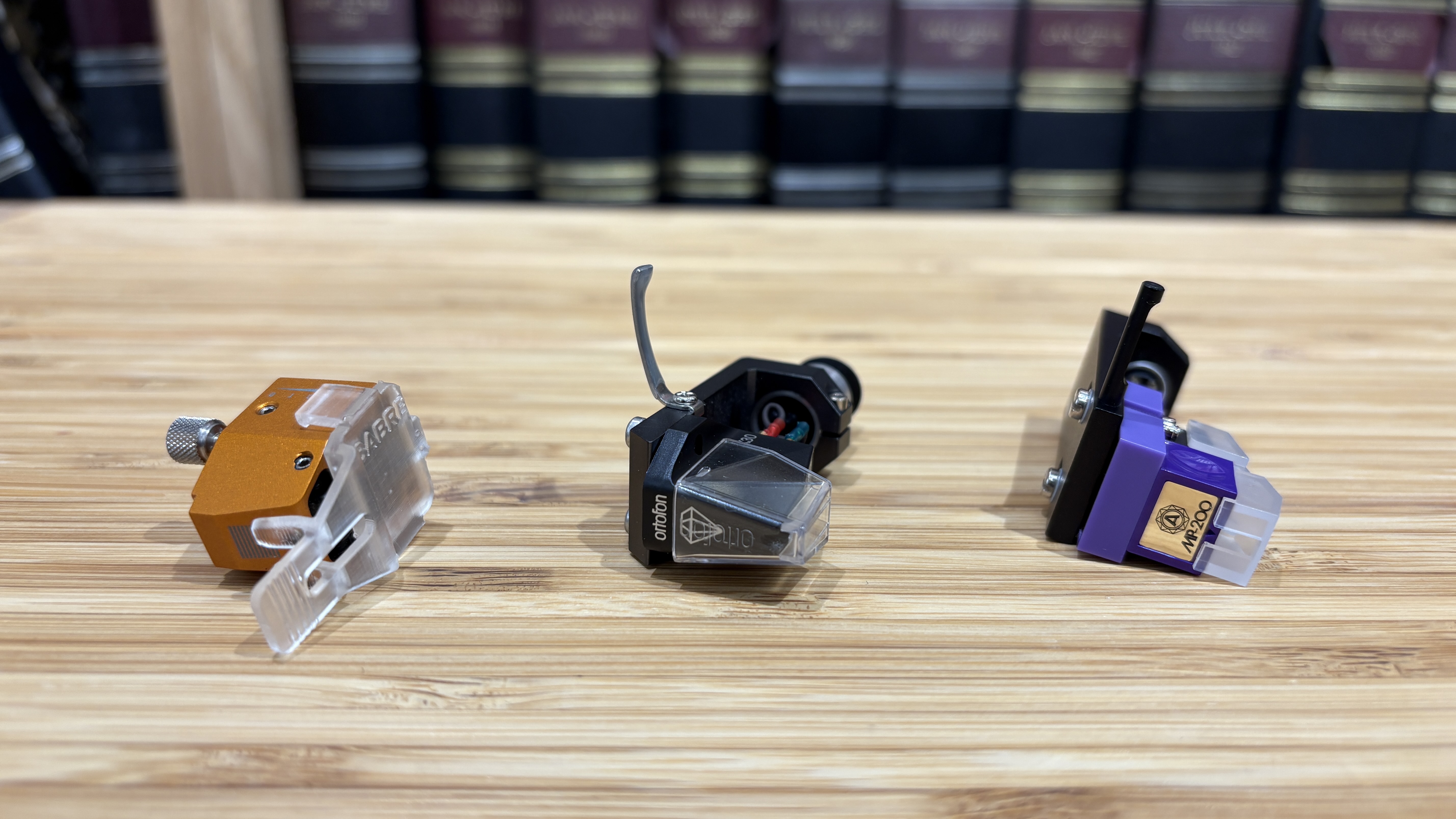 Vertere Sabre, Ortofon MC X30 and Nagaoka MP200 cartridges placed in a row on a wooden rack