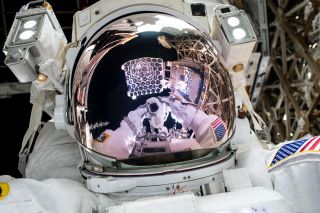 The NICER X-ray telescope is reflected on NASA astronaut and Expedition 72 Flight Engineer Nick Hague's spacesuit helmet visor in this high-flying "space-selfie." Also, visible in Hague's visor is the camera he is pointing toward himself to take this photograph.