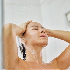 woman soothing her dry scalp in the shower