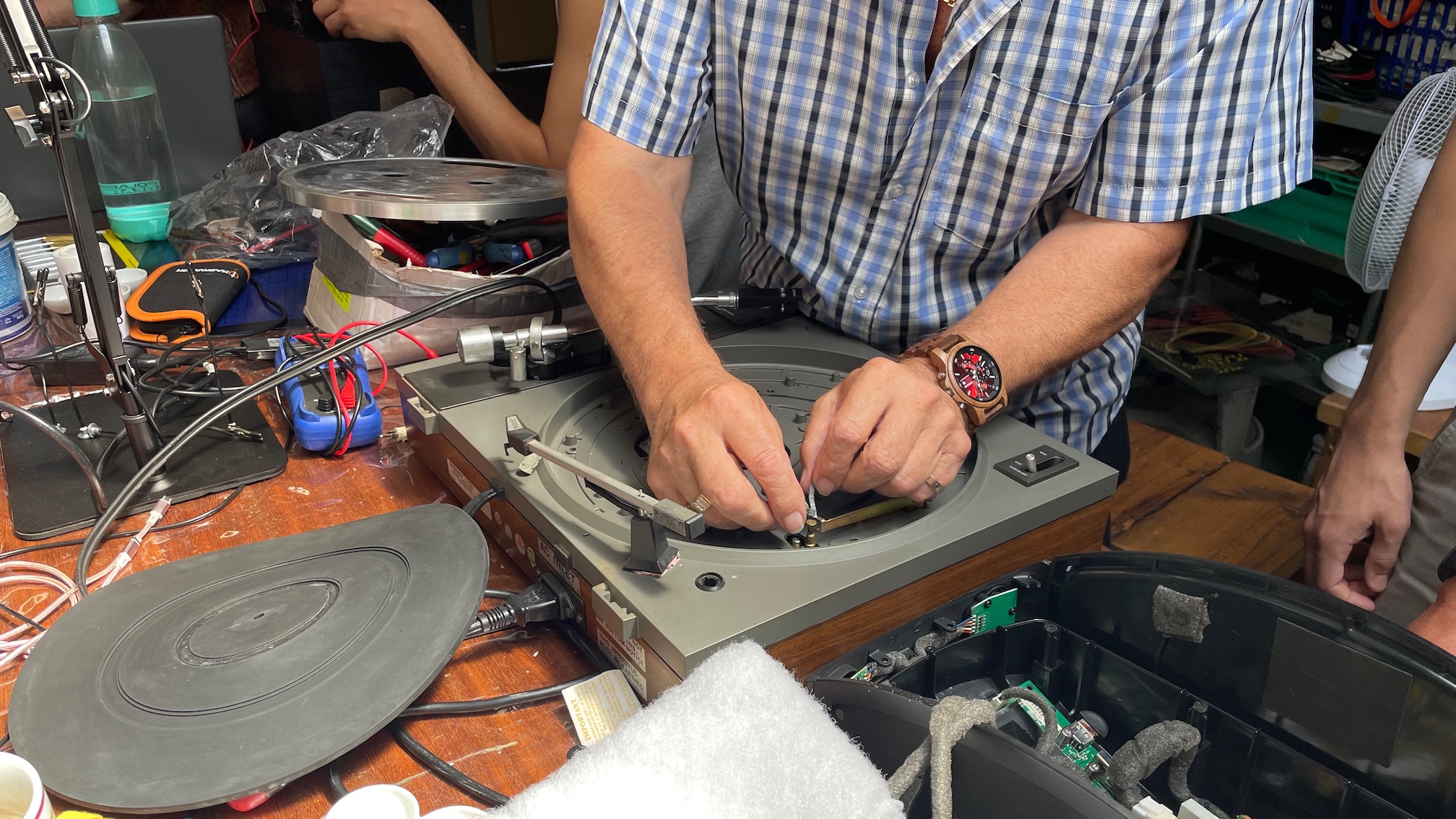 A man repairing a Pioneer PL-112D turntable.