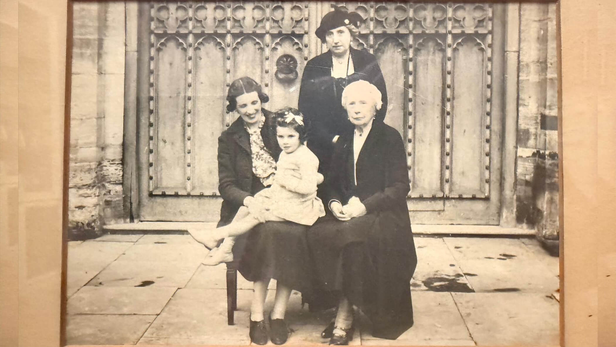 Black-and-white group portrait of four generations of women in the same family. 