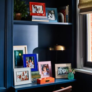 Multicoloured bobbin frames inside a navy blue alcove