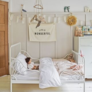 Nursery with neutral colour scheme and white metal child's bed
