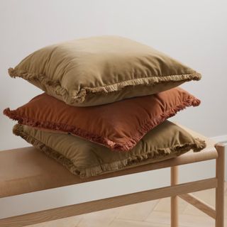 Three warm-toned throw pillows from Net-A-Porter