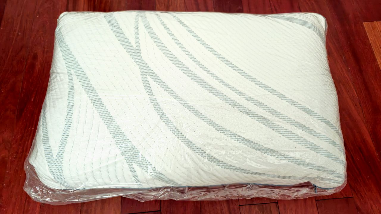 The Tempur-Pedic Tempur-Adapt ProAdjust Pillow wrapped in plastic on a redwood floor