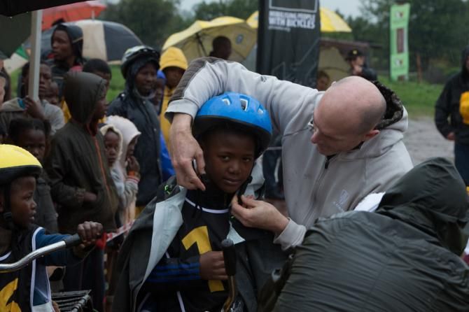 Trek's Scott Daubert helps a competitor with his helmet
