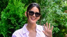 Olivia Munn in black sunglasses and a white shirt