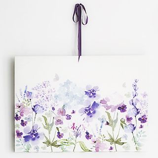 room with springtime bloom canvas with purple ribbon on white wall