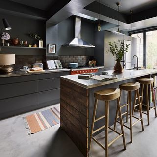Black kitchen with island and wooden bar stools