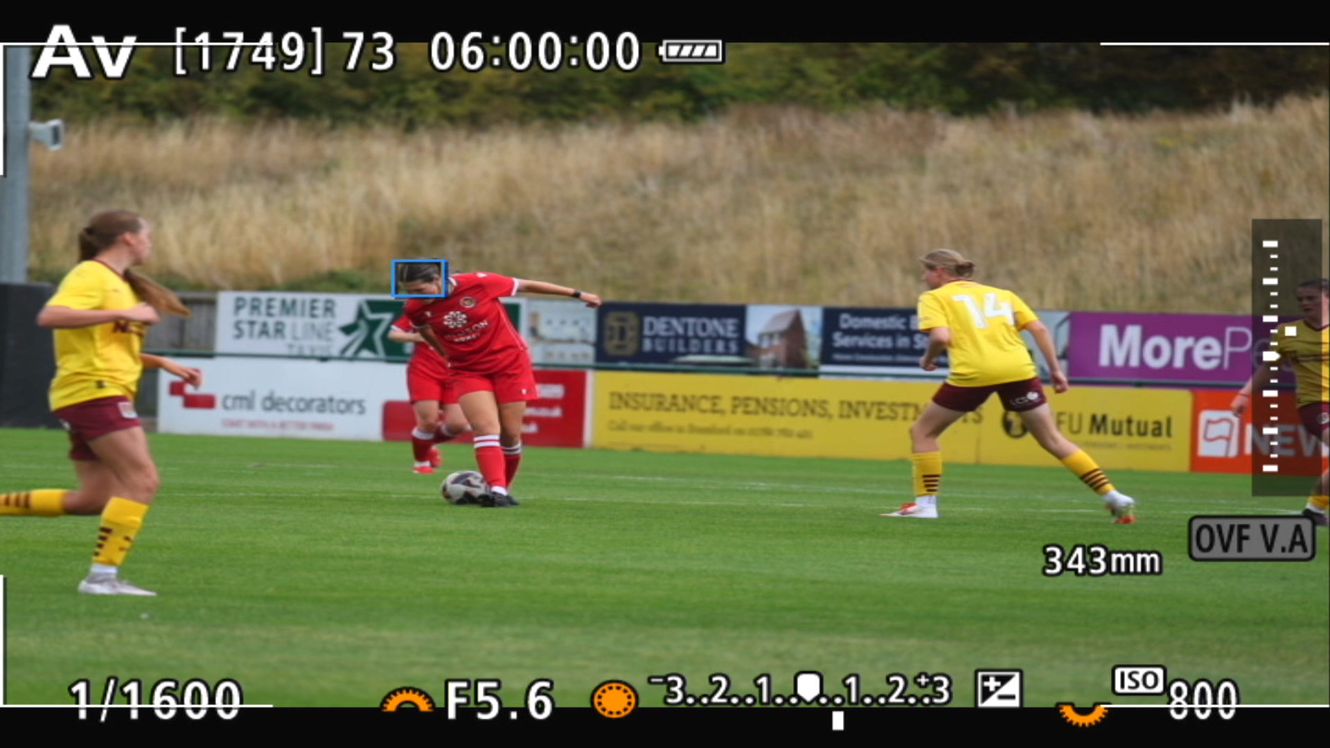 A screengrab from a Canon camera showing the Action Priority locking on to a soccer player with a blue autofocus box over the head of the player with the ball
