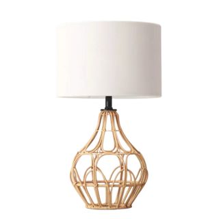 A rattan based lamp with a white lampshade