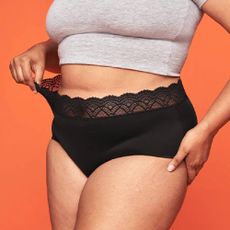 Close up of a model wearing a pair of black briefs from Thinx.