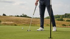 Pressing down old hole plug on the line of a putt