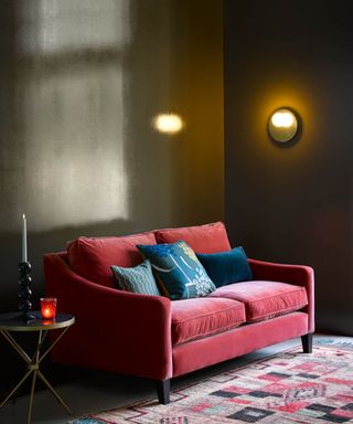 dark living room with gloss dark green walls and red sofa