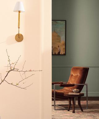 a living area with Antique Pewter walls and a brown suede armchair, looking through from the hallway with soft pink walls