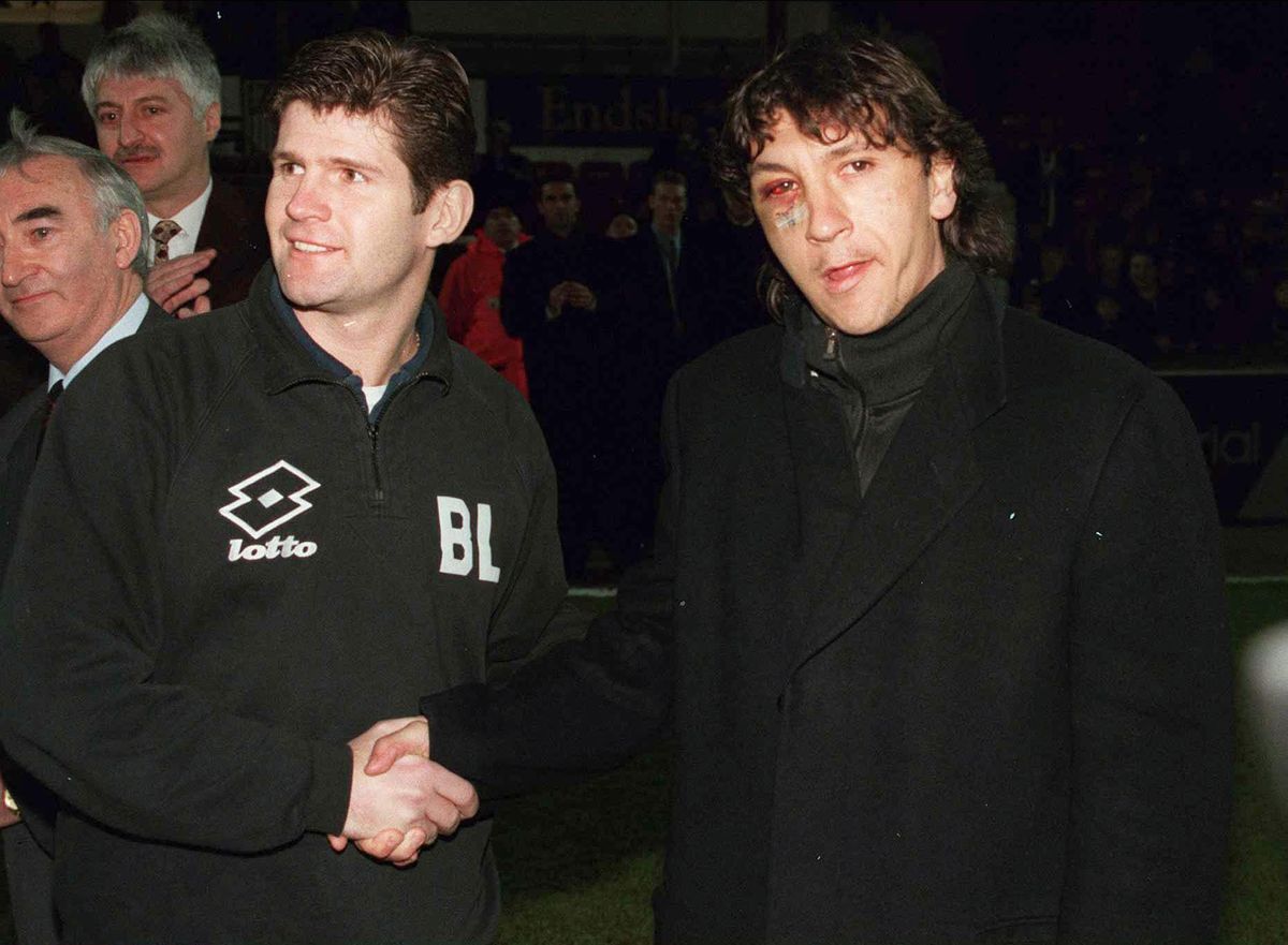 Grimsby Town manager Brian Laws shakes hands with player Ivano Bonetti, who is sporting a visibly injured eye after being hit by a plate of chicken wings thrown by Laws during a row, February 1996