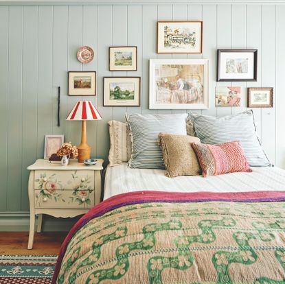 bedroom with tongue and groove wooden planelling and picture gallery wall above bed