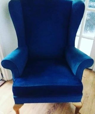 blue velvet armchair with wooden flooring