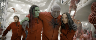 (L to R) Zoe Saldaña as Gamora carrying Dave Bautista as Drax with help from Pom Klementieff as Mantis in Guardians of the Galaxy Vol. 3