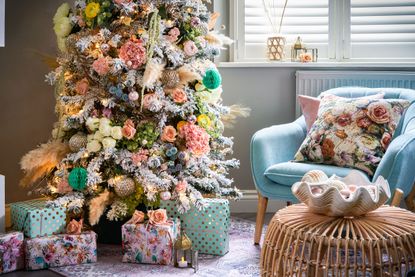 Cottagecore style Christmas tree with shades of blue and pink, staged coffee table to the right with shell display piece