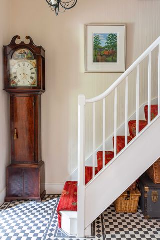 stairway with black and white tiles and grandfather clock