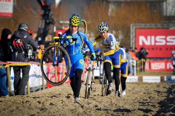 Daphny van den Brand (AA Drink - Leontien.nl) shoulders her bike through a sand section.
