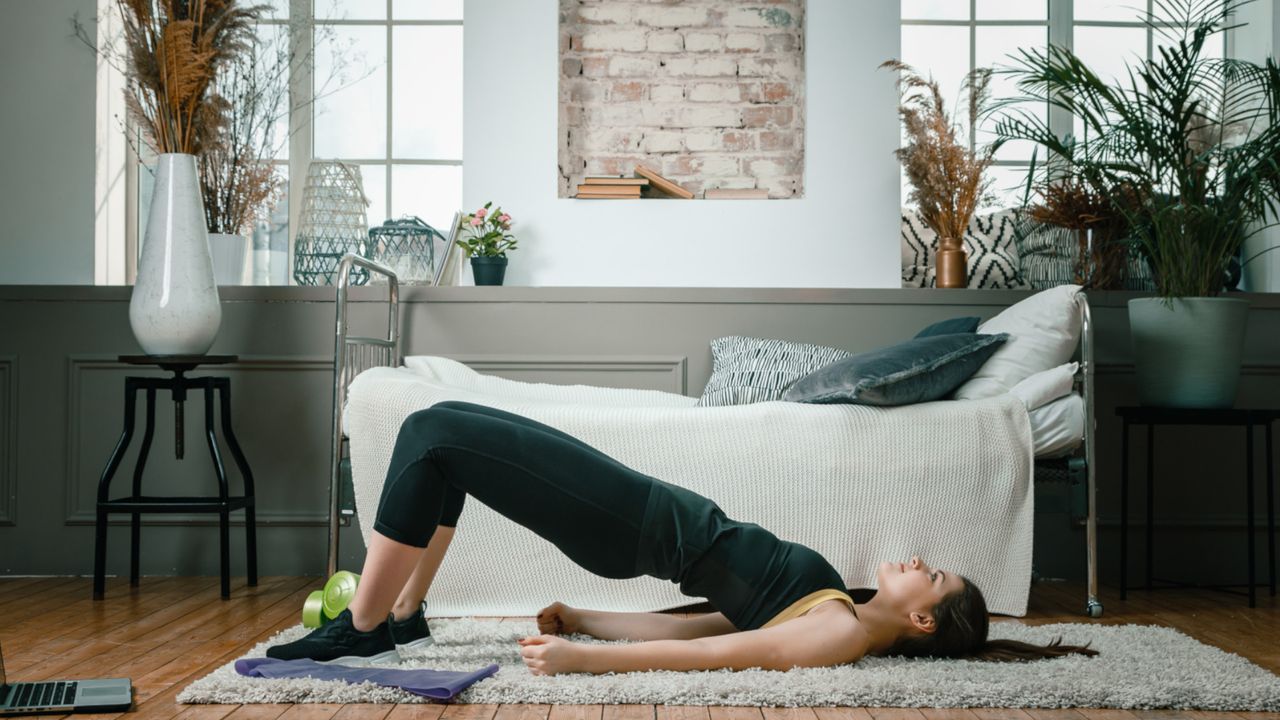 A woman performing glute bridges at home for her lower back