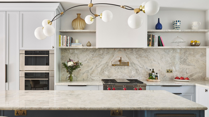 large modern kitchen with blue cabinets and marble surfaces