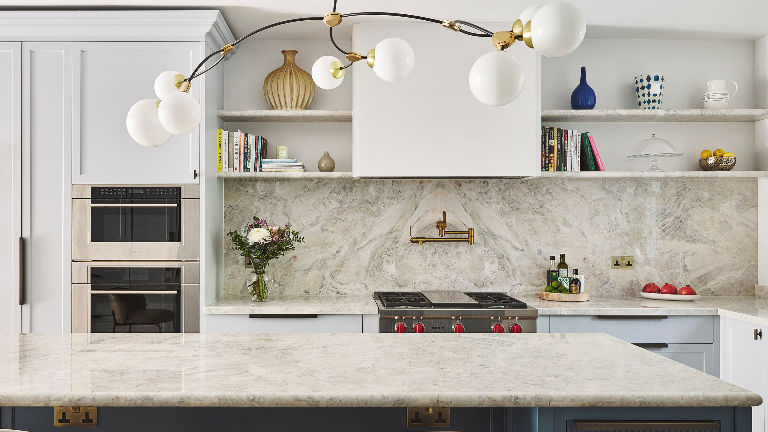 large modern kitchen with blue cabinets and marble surfaces