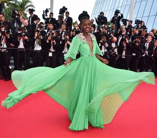 lupita nyong'o twirls in a green pleated gown at the cannes film festival