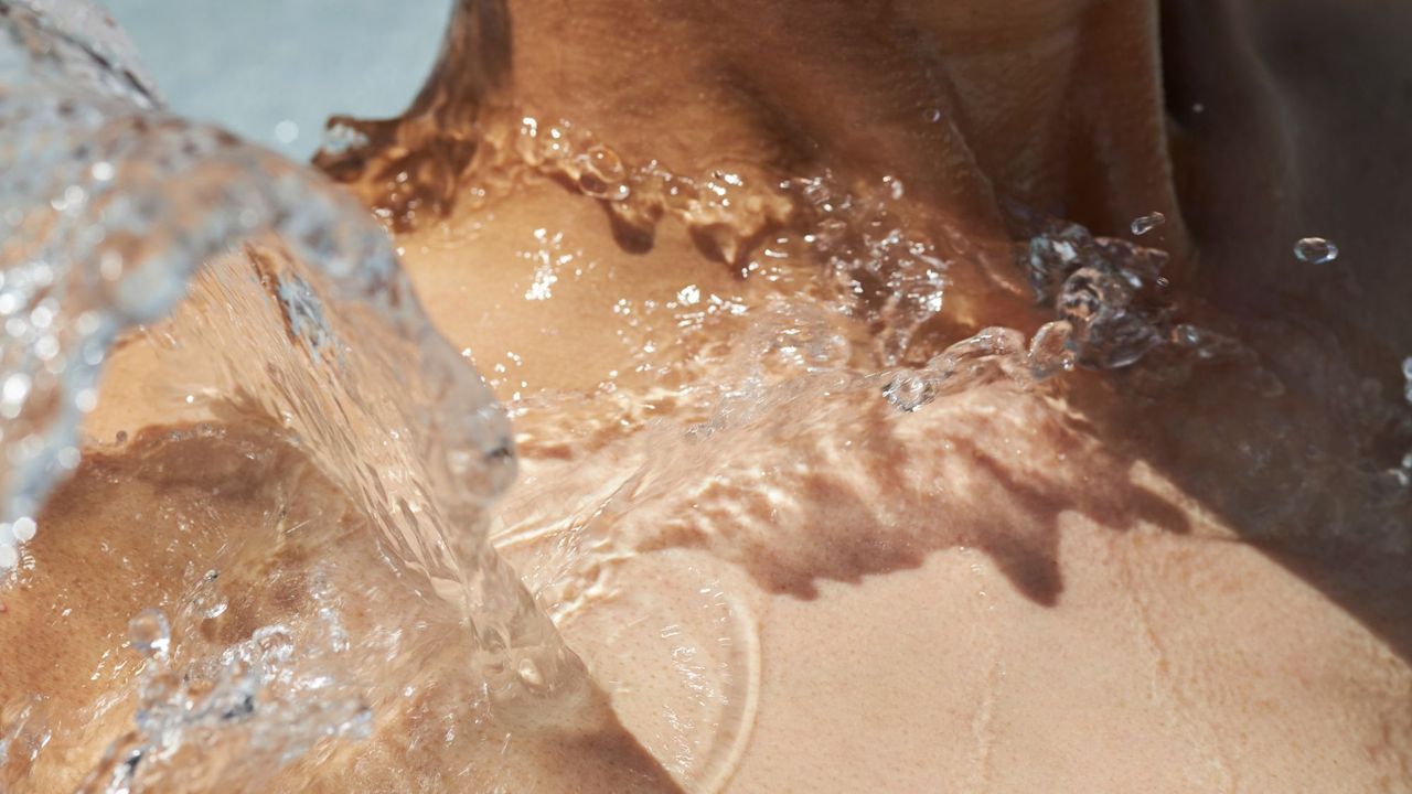 Types of vibrator: A woman with water splashing on her collarbone 