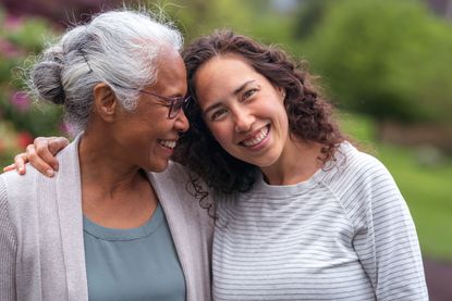 A woman leans her head on the shoulder of her grandmother