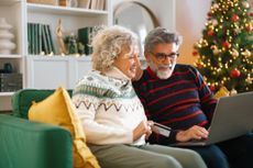 A couple shopping online for Christmas gifts at home
