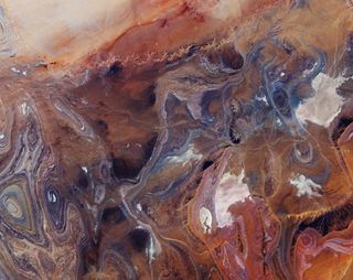 This stunning, sandy, sienna-hued landscape is the Tanezrouft Basin (a desolate region of the Sahara Desert) as seen by the Copernicus Sentinel-2 from space. The extremely arid plain is home to scorching temperatures, little water and vegetation and has even been nicknamed the "Land of Terror." This image was captured as part of Copernicus Sentinel-2, a two-satellite mission that is part of the European Space Agency's Copernicus program.