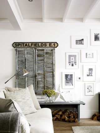 A rustic cream and grey living room with TV behind shutters