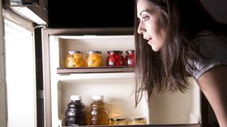 woman-looking-in-fridge-for-late-night-snack