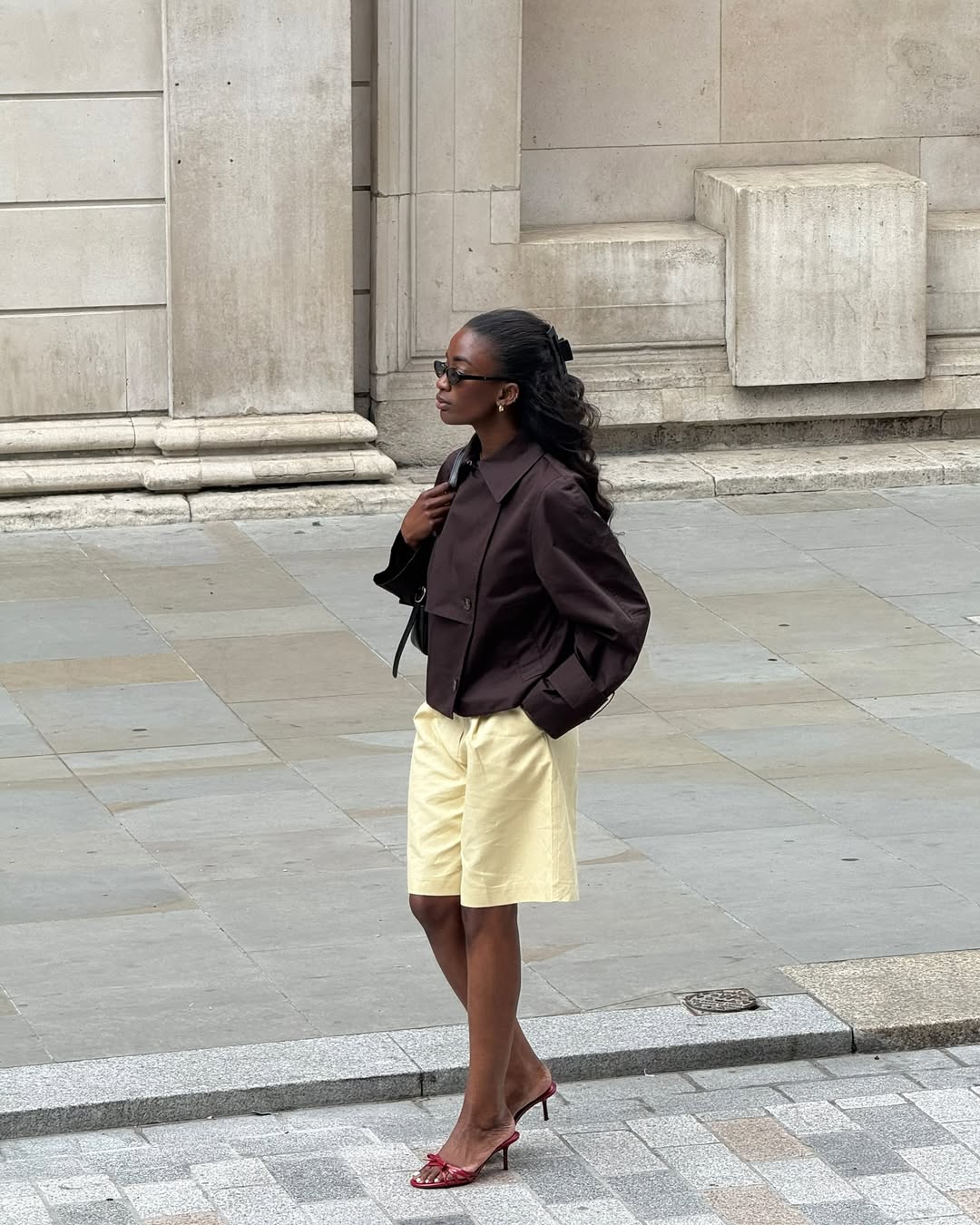 Woman Wearing Yellow Shorts, Brown Jacket, and Red Heels