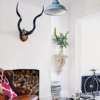 living room with horns plaque and leather carver chair