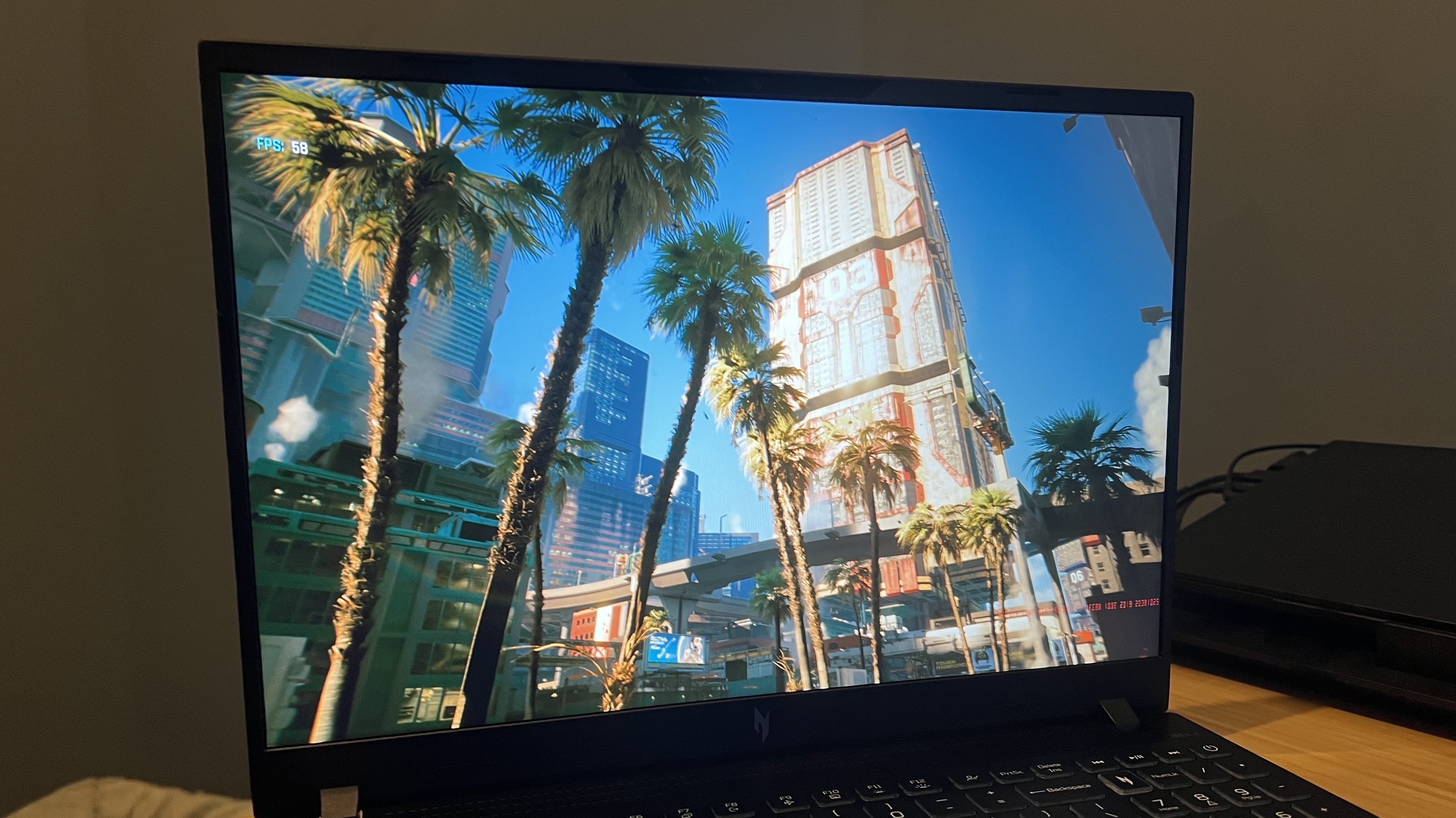 Screen of Acer Nitro V 16 AI gaming laptop running a benchmark test on Cyberpunk 2077