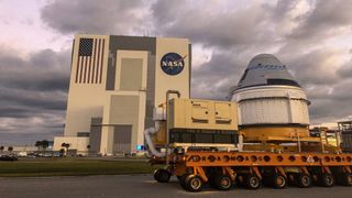 Boeing's CST-100 Starliner capsule seen in front of the Vehicle Assembly Building at NASA's Kennedy Space Center as it began its journey on Nov. 21, 2019, to Cape Canaveral Air Force Station for launch.