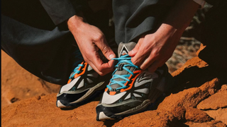Runner tying laces on Brooks Cascadia 1 in the desert