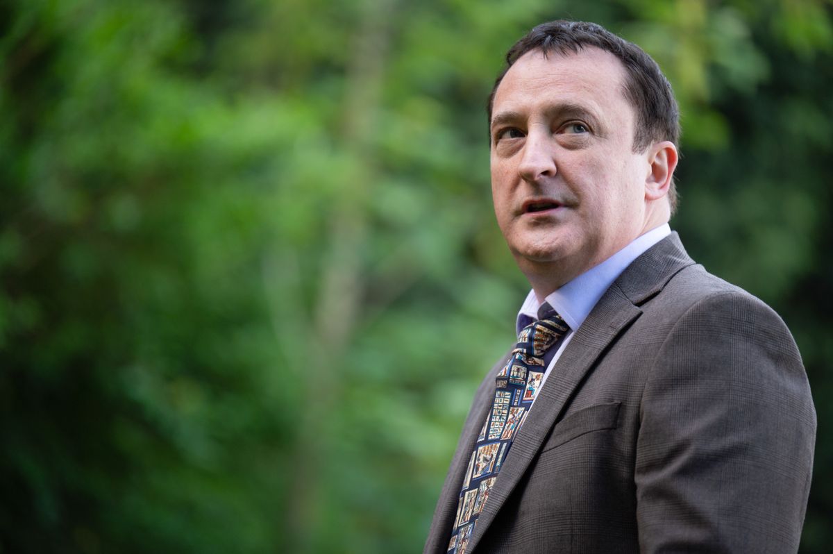 Neil Fitzmaurice, who plays Neil Guthrie in Waterloo Road, standing in front of some trees wearing a suit and tie. 