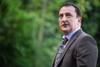 Neil Fitzmaurice, who plays Neil Guthrie in Waterloo Road, standing in front of some trees wearing a suit and tie. 