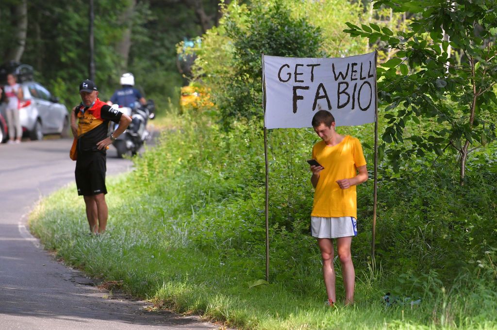A fan holds a sign with get well wishes for Fabio Jakobsen on stage 2 of the Tour de Pologne