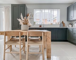 blue kitchen with white worktops and natural wooden rug