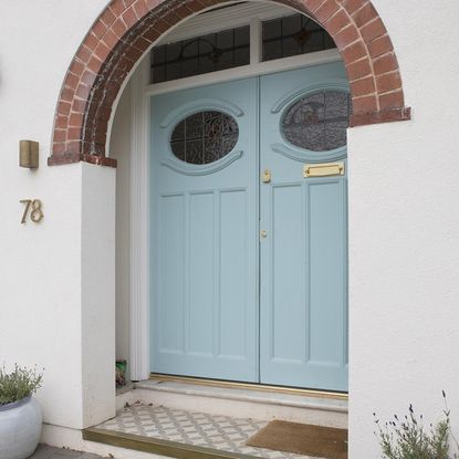 Exterior of house with white walls and blue doors