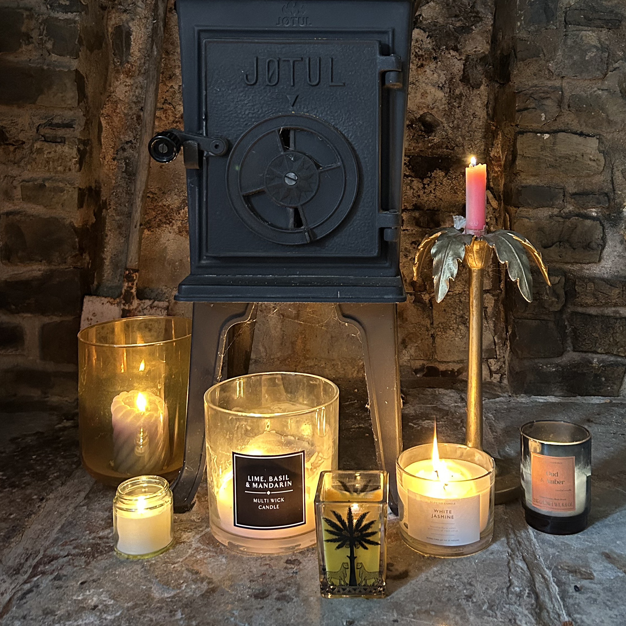 lit candles in front of a wood burner