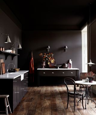 Dark purple kitchen color ideas with wooden flooring, painted cabinets and white countertops.
